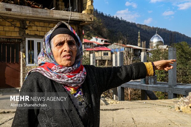 مادری که در حال نشان دادن محل سابق خانه خود در امام زاده ابراهیم می باشد که بعد از آوار برداریف بلاتکلیف رها شده